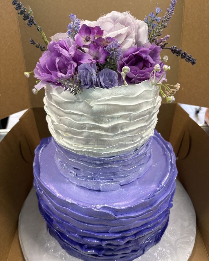 Pastel de dos pisos con flores moradas hecho en Kairo's